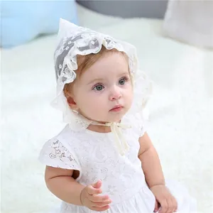 Detail of baby white lace sun hat and dress with intricate mesh and ribbon ties