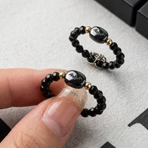 Close-up of beaded rings with black faceted beads and cute cat head shaped charms