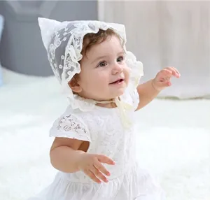 Detailed embroidery and lace ruffle texture on white newborn dress and matching hat