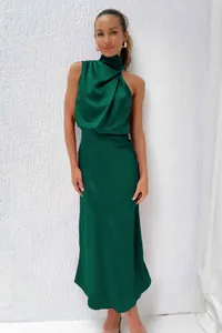 Détail de la robe longue en satin vert émeraude montrant les plis et la texture soie