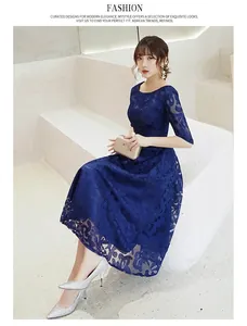 Détail de la robe en dentelle florale bleu foncé avec manches élégantes pour soirées