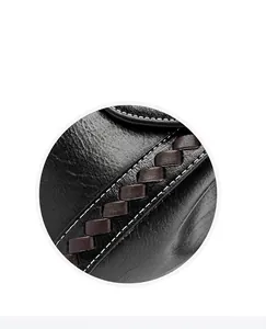 Detail of black lychee leather bag with white stitching and brown woven side trim