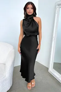 Détails d'une robe midi élégante en satin noir avec licou et décolleté drapé sophistiqué