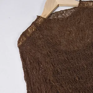 Close-up of deep brown lace dress featuring intricate hollow-out floral patterns
