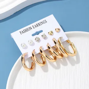 Fashion earring set with gold hoops, pearls, and crystal studs on display card