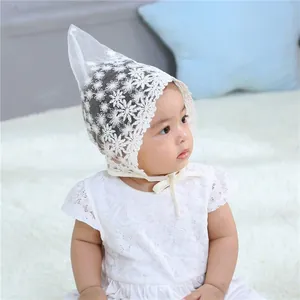 Detail of baby lace bonnet featuring delicate floral mesh and elegant ruffled edges