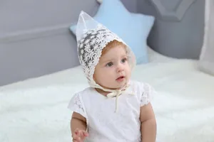 Detail of baby girl white lace dress with daisy floral patterns for 100-day photo shoot