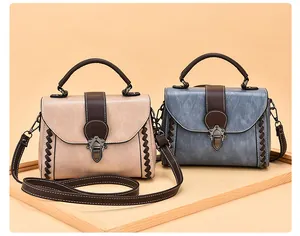 Detail of vintage beige and blue-grey leather handbags with bronze locks and woven texture