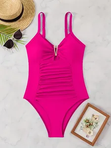 Detail of rose red one-piece swimsuit with V-neck, gold buckle and slimming ruched fabric
