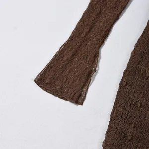 Detailed close-up of dark brown crochet lace texture on elegant long sleeve dress