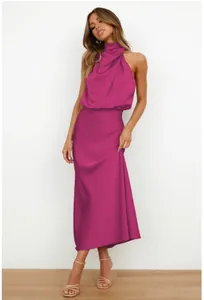 Détail d'une robe maxi en satin fuchsia montrant l'élégant décolleté drapé et plissé