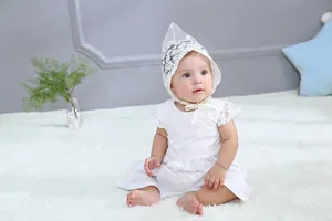 Close-up of white floral embroidery lace and ribbon ties on a baby princess outfit