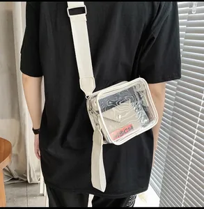 Detail of transparent PVC crossbody bag with wide fabric strap and internal cream pouch