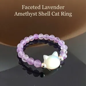 Macro shot of beaded lavender purple jade ring with white shell cat head carving