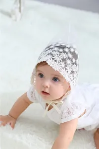 Detailed close-up of white floral lace texture on baby princess photography bonnet