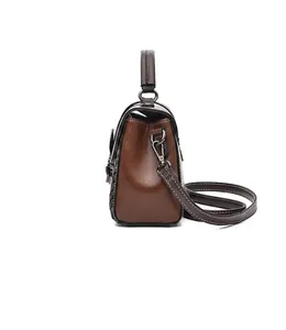 Side view of dark leather handbag with detailed white contrast stitching and shoulder strap