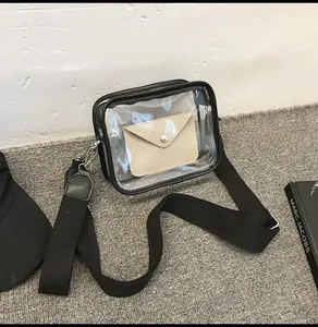 Macro detail of clear PVC bag featuring black canvas strap and beige inner pouch