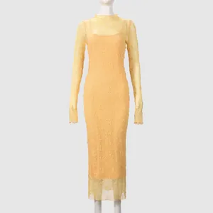 Detailed texture of yellow lace long sleeve dress featuring an elegant crochet pattern