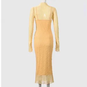 Detail of sheer yellow lace fabric and textured floral pattern on a long sleeve maxi dress