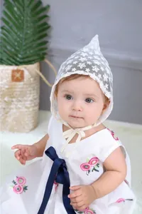 Close-up of baby lace pointed hat with delicate flower embroidery and mesh texture