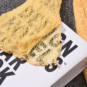 Macro shot of yellow lace fabric showing intricate mesh texture and seam details