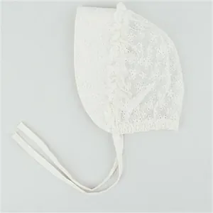 Close-up of baby lace bonnet featuring delicate floral embroidery and scalloped edges