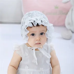 Close-up of white baby lace bonnet featuring ruffled edges and delicate mesh texture