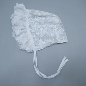 Detailed view of the intricate floral lace embroidery and ruffled edges on this baby bonnet