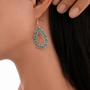 Close-up of vintage flower teardrop earrings with turquoise beads on model