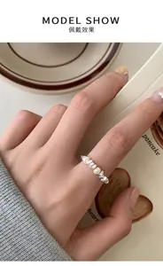 Close-up of S925 sterling silver wavy ring with freshwater pearls on a finger