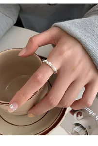 Detailed view of S925 sterling silver wave ring with freshwater pearls on model