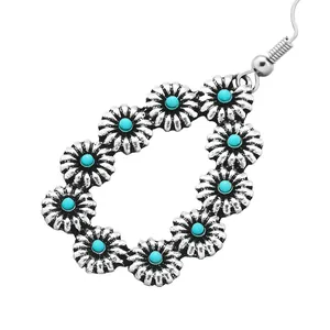 Vintage teardrop earrings featuring turquoise sunflower charms in antique silver finish
