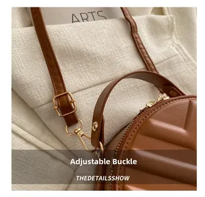 Close-up of the metal adjustable buckle and quilted texture on a brown crossbody bag