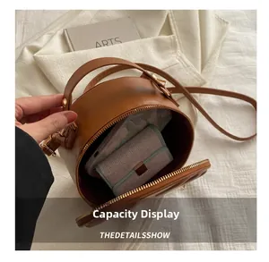 Brown circular crossbody bag capacity display showing internal phone and wallet storage