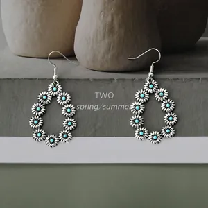 Close-up of vintage silver alloy drop earrings with daisy motifs and turquoise beads