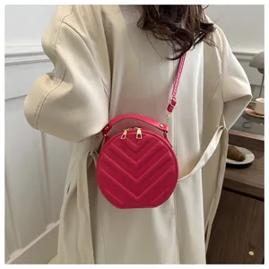 Fashionable rose red round crossbody bag with quilted V-pattern and adjustable strap