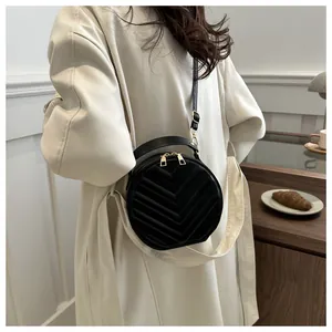 Classic black round quilted crossbody bag with golden zipper detail and stylish top handle