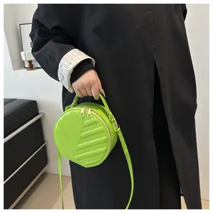 Close-up of a vibrant neon green round crossbody bag with leaf-vein quilted texture