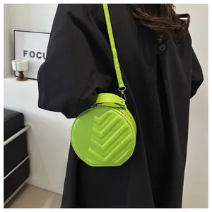 Detail of lime green round crossbody bag featuring V-shaped embossed faux leather