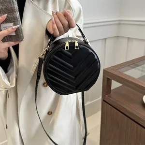 Chic black chevron quilted circular crossbody bag with gold zippers and top handle