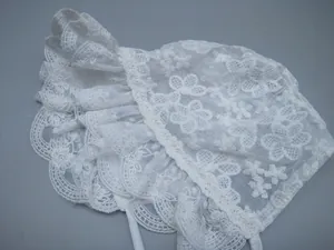 Detailed view of white baby lace bonnet featuring delicate floral embroidery and ruffled brim