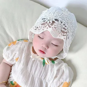 Close-up of light blue lace baby bonnet with floral embroidery and ruffle trim