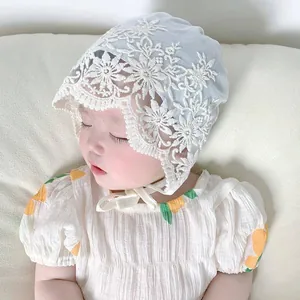 Close-up of baby lace bonnet featuring intricate floral patterns and soft tie closure
