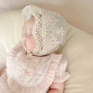 Detailed embroidery on white lace baby bonnet with soft satin bow top for infants