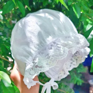 Detailed view of delicate floral lace embroidery on white vintage baby bonnet