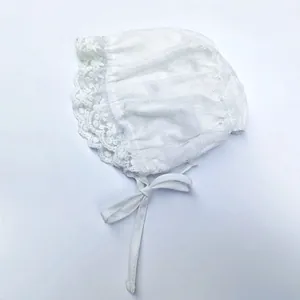 Close-up of baby lace bonnet featuring delicate floral embroidery and cotton ties