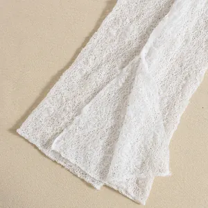 Detailed macro view of the cream white lace fabric with mesh texture and polka dots