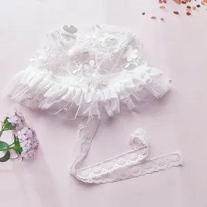 Detail of white lace baby princess hat with 3D flower embroidery and pearl accents