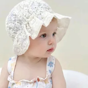 Close-up of white baby lace bonnet featuring delicate floral embroidery and wavy brim