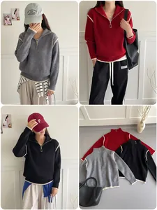 Detail of half-zip knit sweater with white contrast piping and metal zipper closure